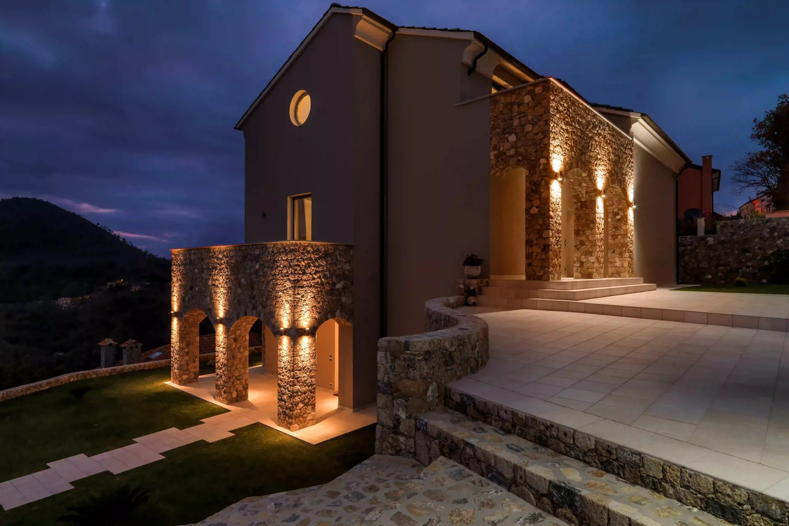 A Dramatic View Of A Home's Facade Illuminated By Accent Lighting, Highlighting Architectural Details.