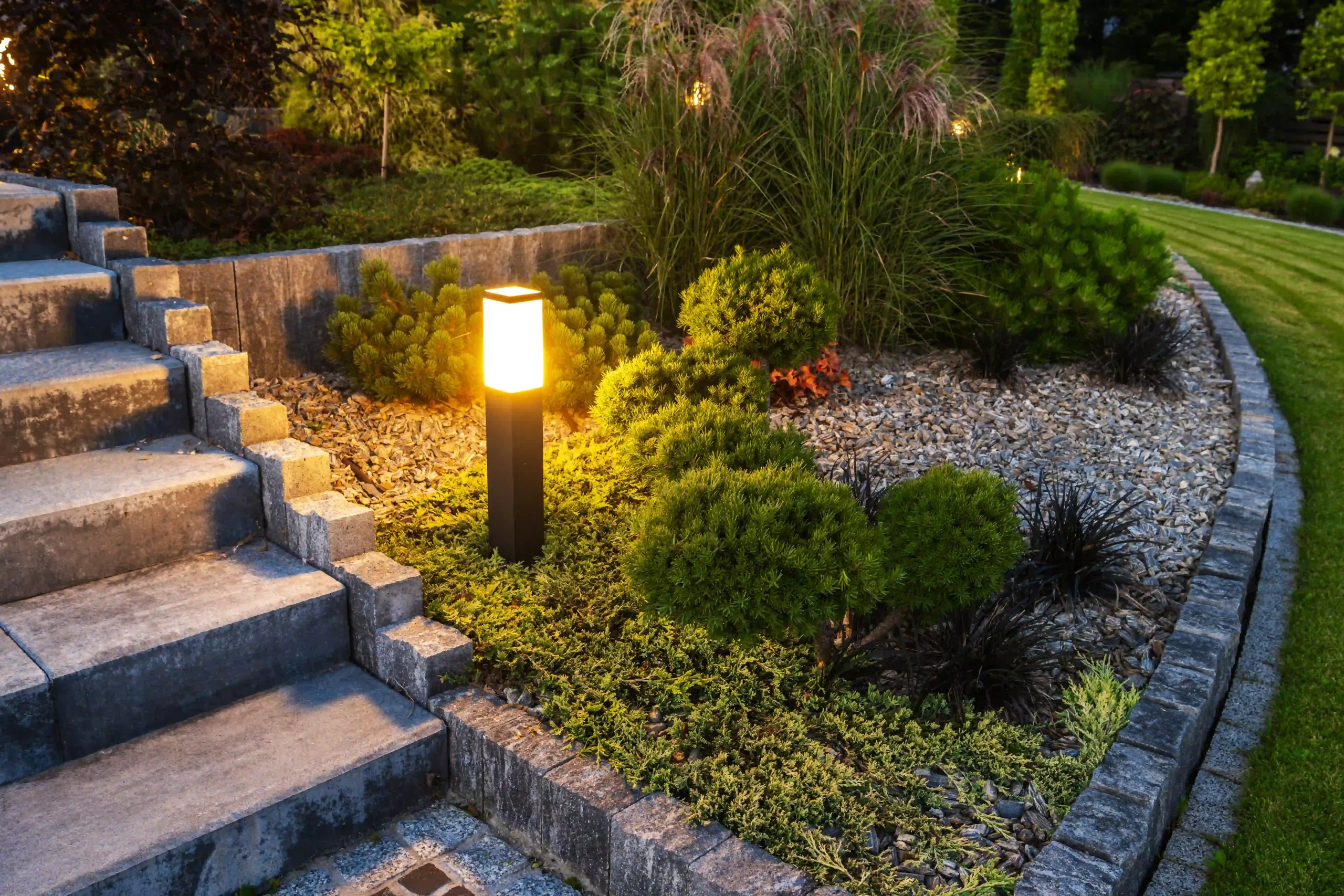 A Garden Vibrantly Lit By Landscape Lighting, Showcasing Trees, Shrubs, And Pathways.