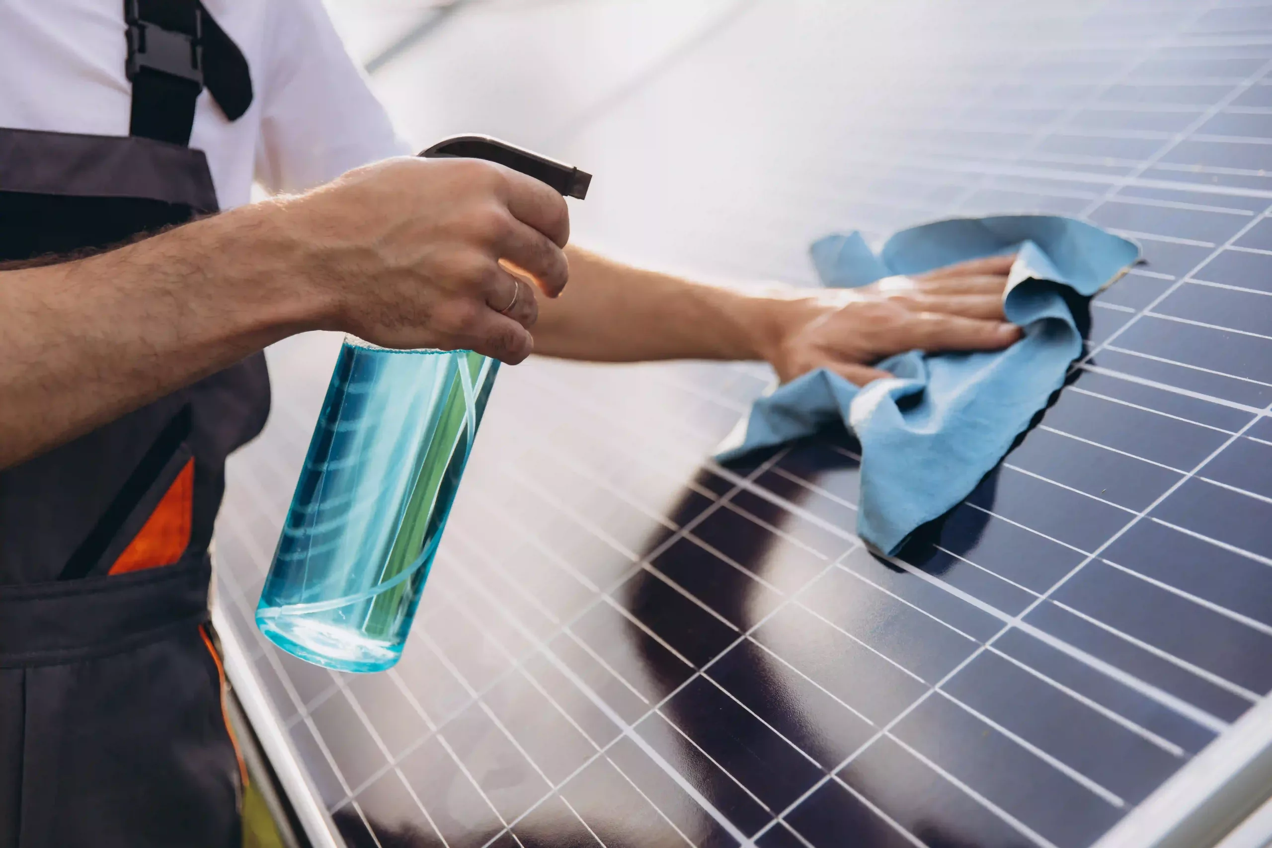 Close Up Of A Worker Cleaning Solar Panels At A Solar Power Plant Or Farm