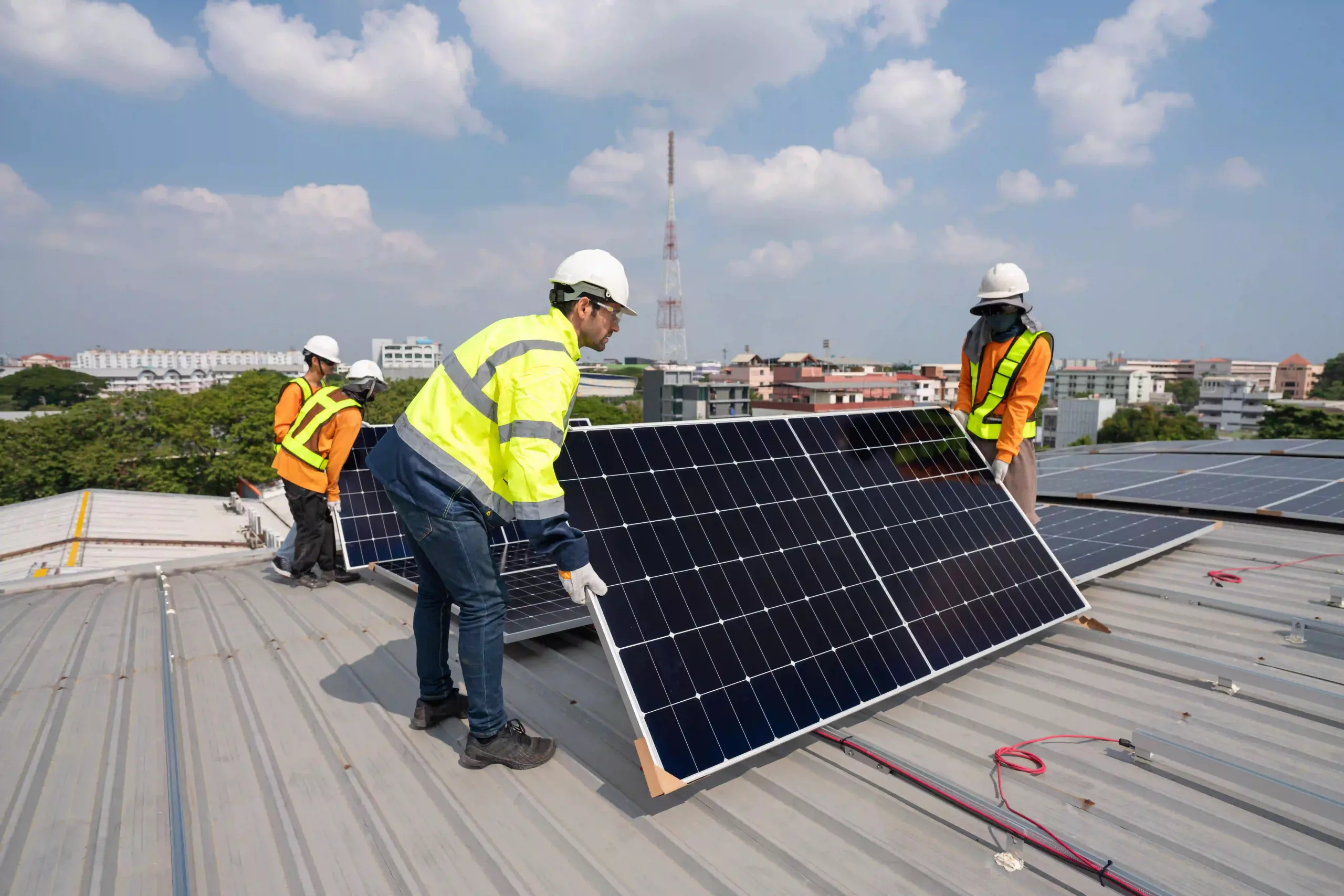 Team Technicians Carrying Photovoltaic Solar Moduls On Roof